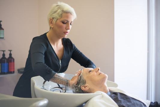 a worker shampooing a customers hair