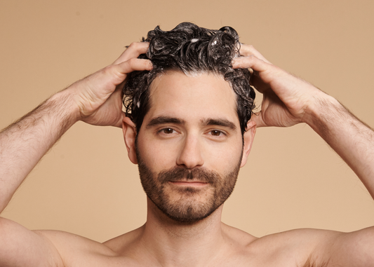Handsome male model washing hair with sulfate-free SEEN Shampoo.